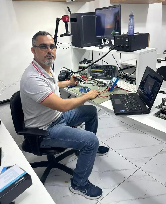 Senildo na bancada do laboratório da SSTech, consertando uma placa-mãe de notebook