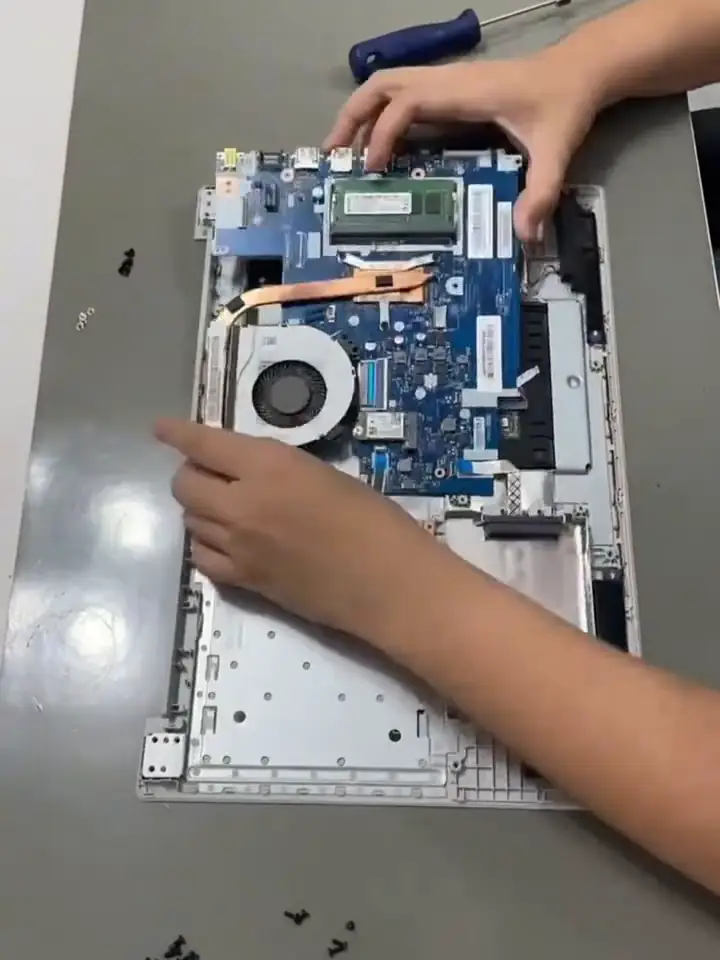 Notebook aberto na bancada, com a placa-mãe à mostra