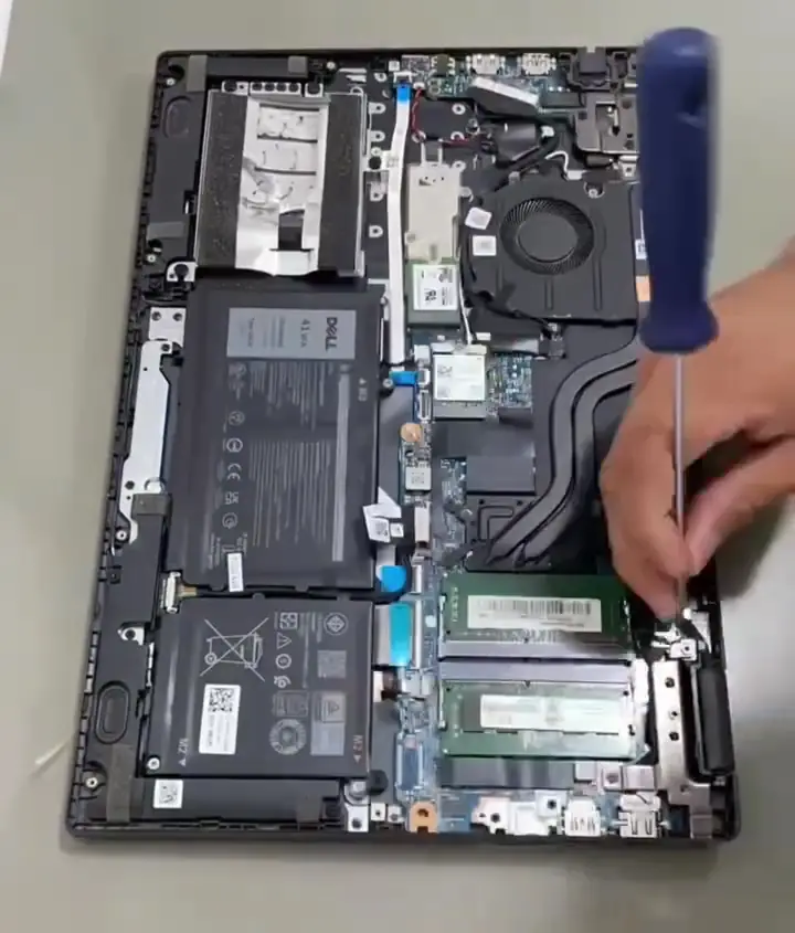 Notebook aberto na bancada da SSTech, com a placa-mãe à mostra